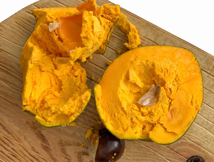 Aufgeschnittene Lucuma-Frucht mit orangefarbenem Fruchtfleisch